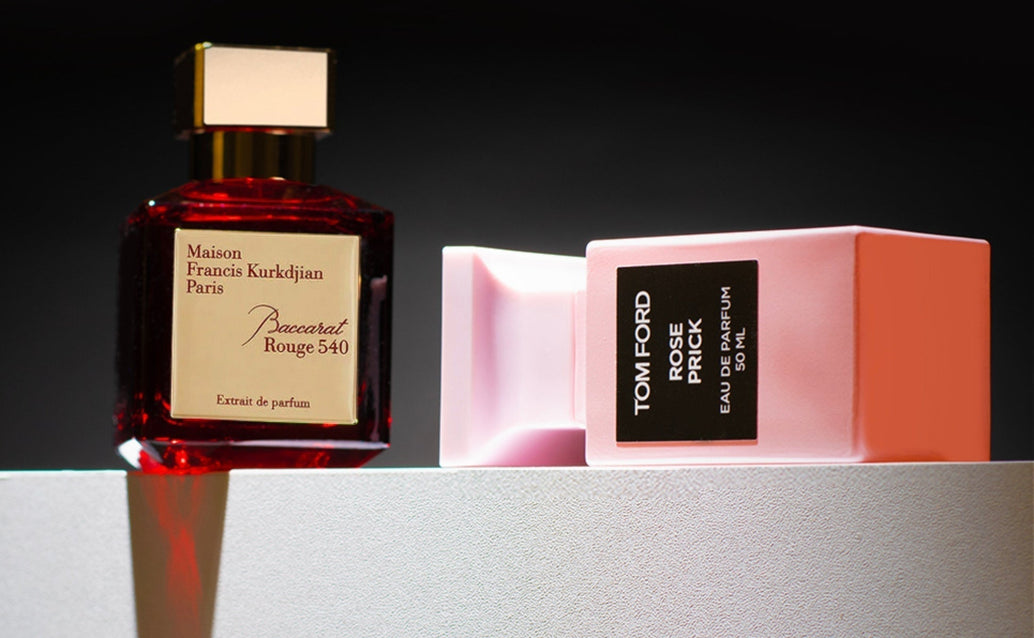 Maison Francis Kurkdjian Baccarat Rouge 540 and Tom Ford Rose Prick perfumes displayed on a minimal surface with dramatic lighting.
