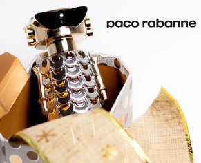 Paco Rabanne perfume bottle with metallic gold and silver design, displayed in a festive gift box with gold ribbon.