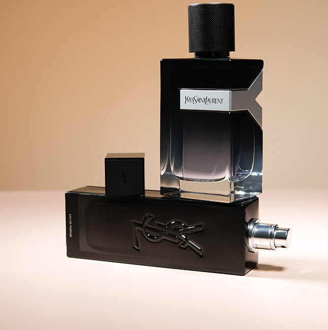 Yves Saint Laurent cologne bottles styled together on a warm beige background.