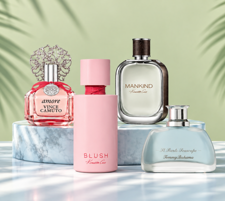 Four fragrance bottles displayed on a marble pedestal against a soft green background.