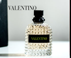 Valentino perfume bottle displayed on a reflective surface with soft lighting and elegant shadows.